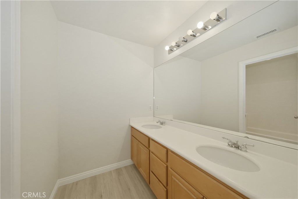 6710 Black Hawk Road Eastvale, CA 92880 - Photo 35 of 49 a spacious bathroom with a sink and a mirror