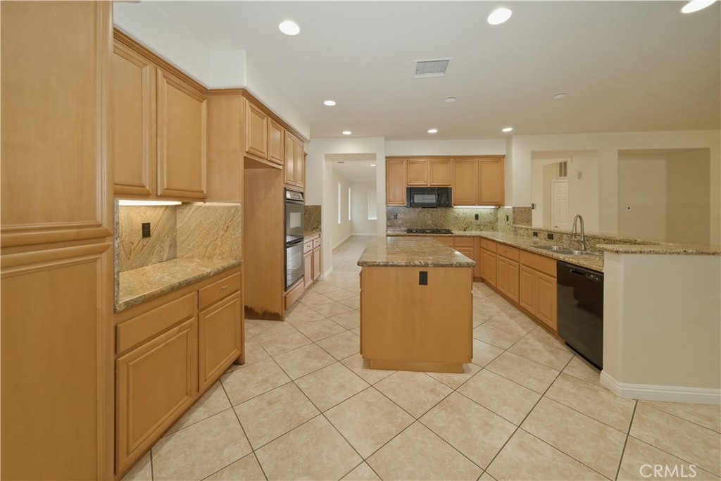6710 Black Hawk Road Eastvale, CA 92880 - Photo 9 of 49 a kitchen with stainless steel appliances granite countertop a stove a sink and a refrigerator