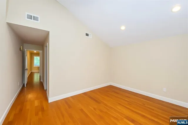 a view of a room with wooden floor and a hallway