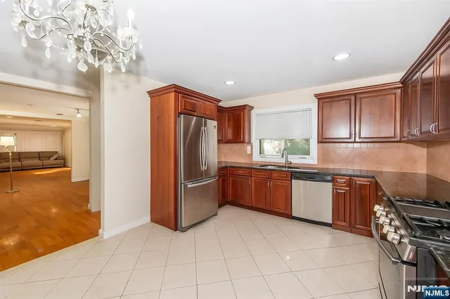 a kitchen with stainless steel appliances granite countertop a refrigerator and a stove top oven