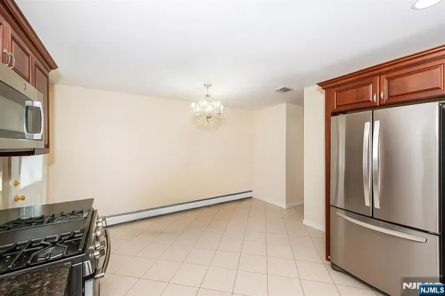 a kitchen with a refrigerator a stove top oven and cabinets