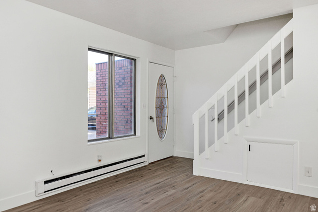 283 West 600 North, Unit 2 Logan, UT 84321 - Photo 9 of 36 Entry area with wood-finish flooring, a white paneled door with an oval stained-glass insert, and a white staircase with spindle railing