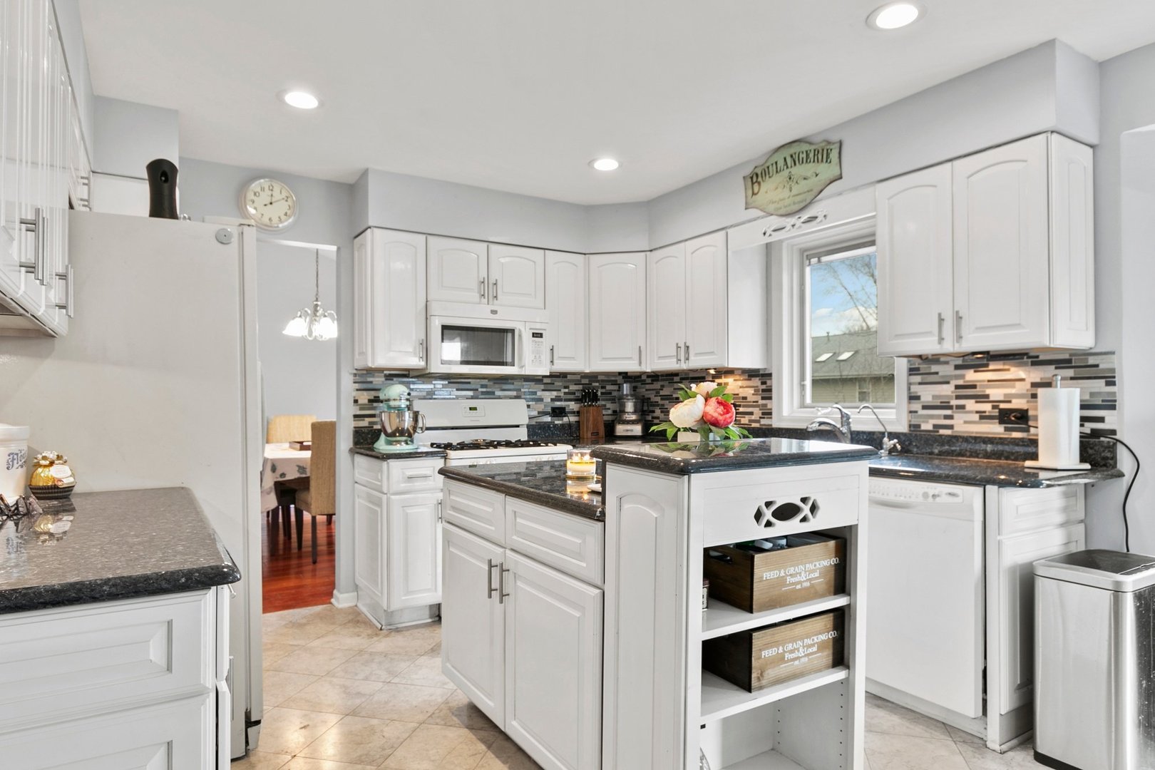 323 Bryan Drive Cary, IL 60013 - Photo 4 of 21 a kitchen with granite countertop white cabinets and white appliances