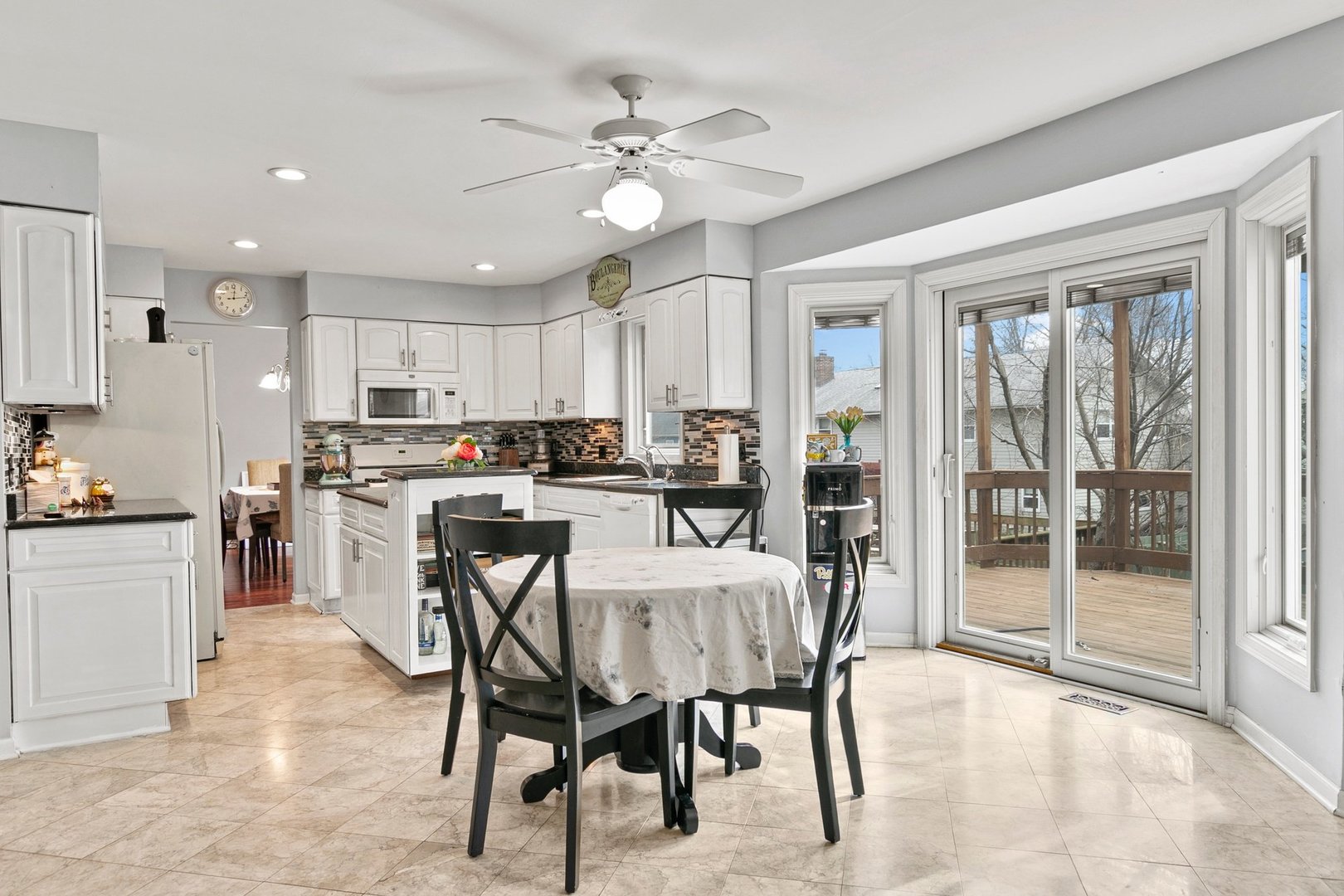 323 Bryan Drive Cary, IL 60013 - Photo 5 of 21 a kitchen with stainless steel appliances granite countertop a stove a refrigerator a sink a dining table and chairs with wooden floor