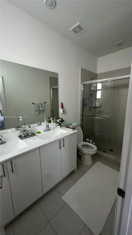 a bathroom with a double vanity sink toilet and shower