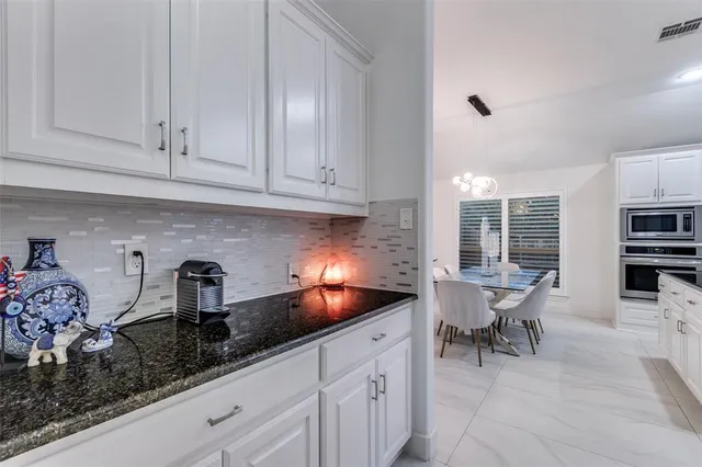 a kitchen with granite countertop white cabinets and sink