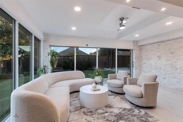 a living room with furniture and a large window with garden view