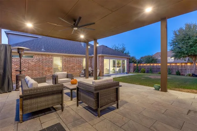 a living room with patio furniture and a fire pit