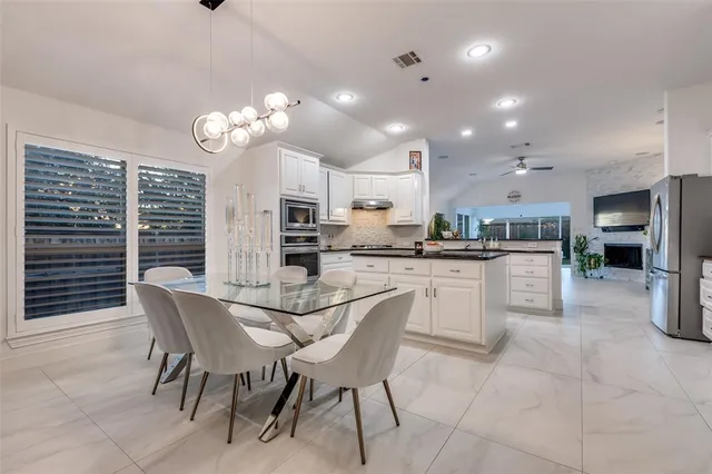 a kitchen with stainless steel appliances kitchen island granite countertop a sink and cabinets