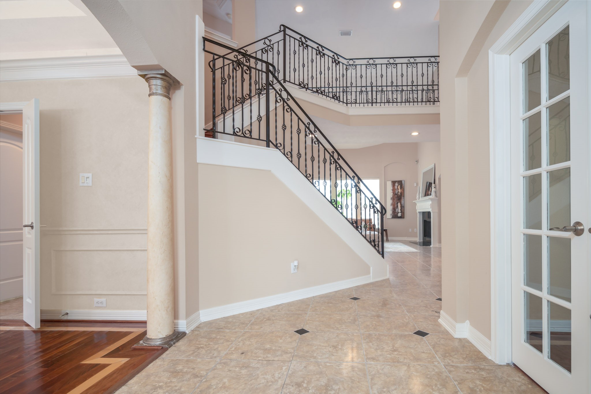 6506 Monte Bello Ridge Lane Houston, TX 77041 - Photo 23 of 39 Welcome HOME to a stunning entryway featuring elegant iron railings, grand columns, and beautiful tile flooring, inviting you into a space of sophistication and warmth.