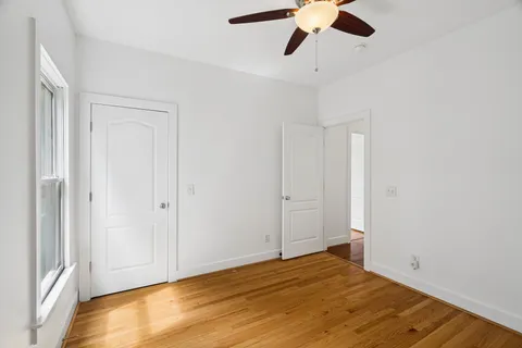 a view of empty room with wooden floor