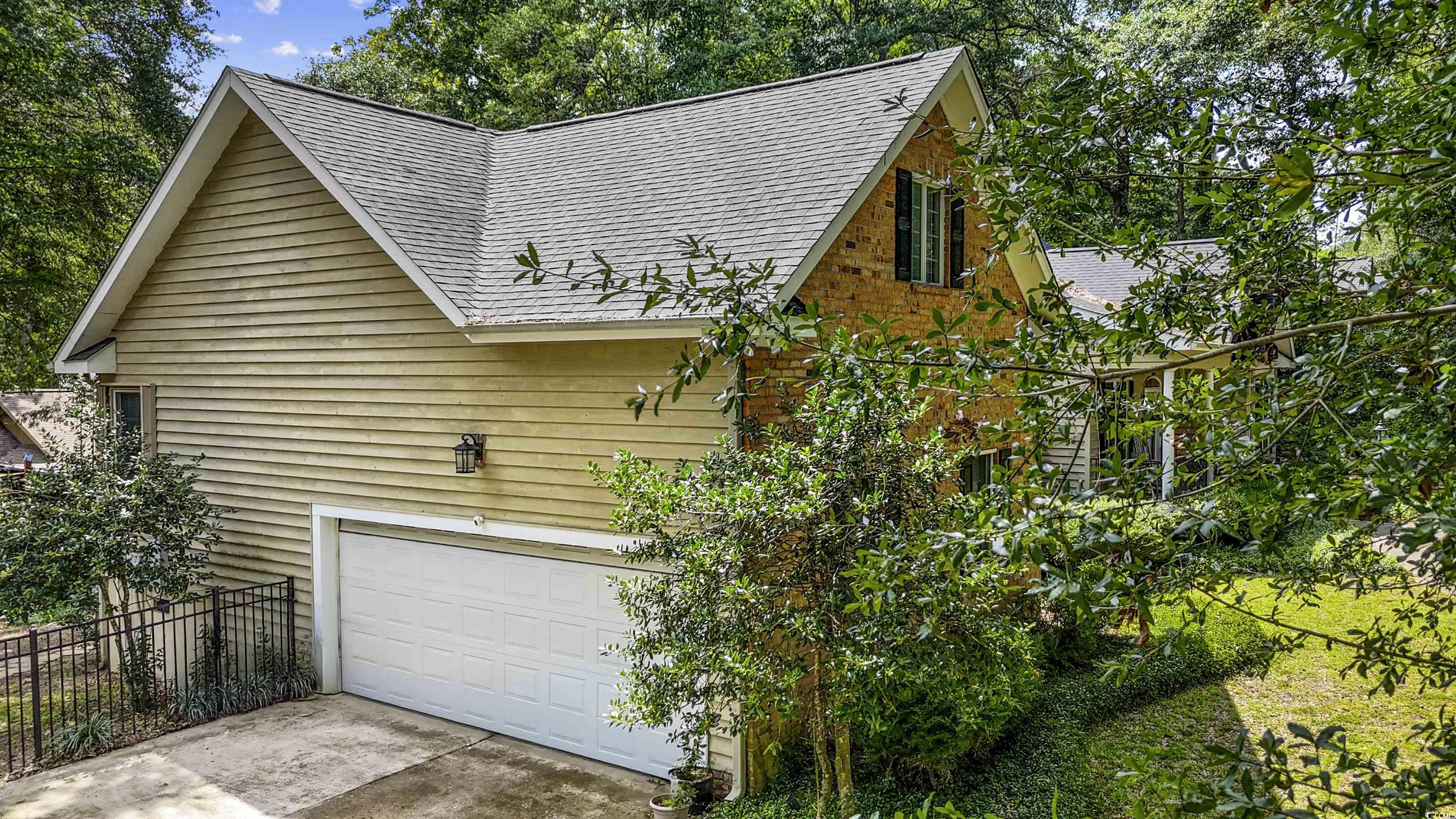 1079 Waterway Lane Myrtle Beach, SC 29572 - Photo 31 of 38 View of front of house featuring a yard, a chimney, a porch, a shingled roof, and brick siding