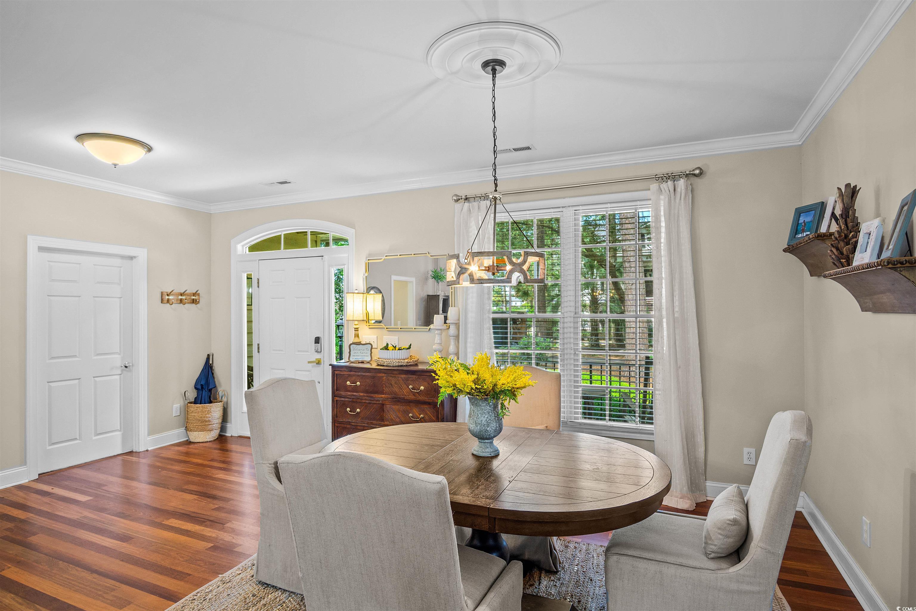 1079 Waterway Lane Myrtle Beach, SC 29572 - Photo 8 of 38 Dining area featuring ornamental molding, dark wood-type flooring, and a chandelier
