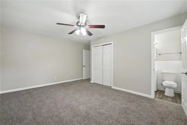 a view of a room with a ceiling fan and a bathroom
