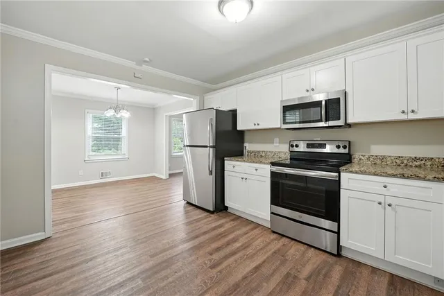 a kitchen with granite countertop a refrigerator stove and microwave