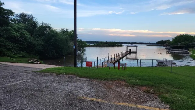 a view of a house with a yard and a large tree