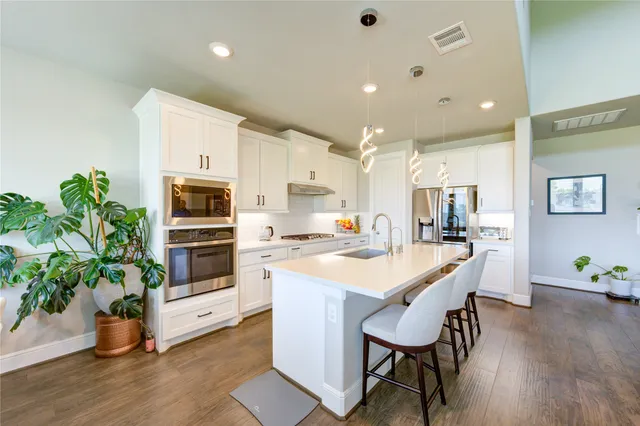 a kitchen with white cabinets and stainless steel appliances