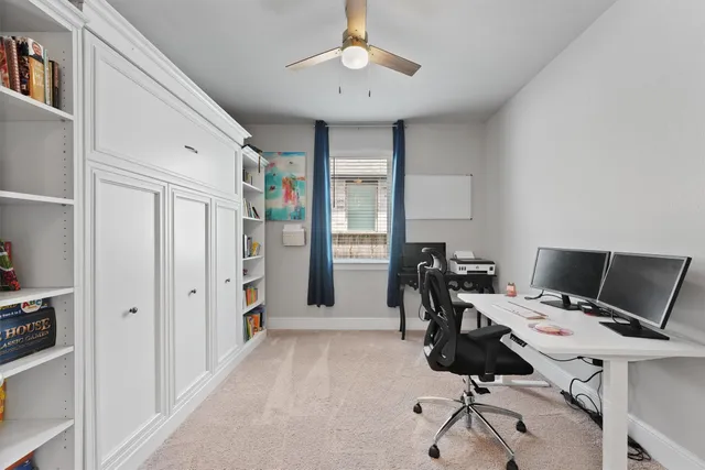 a view of a workspace with furniture and a window