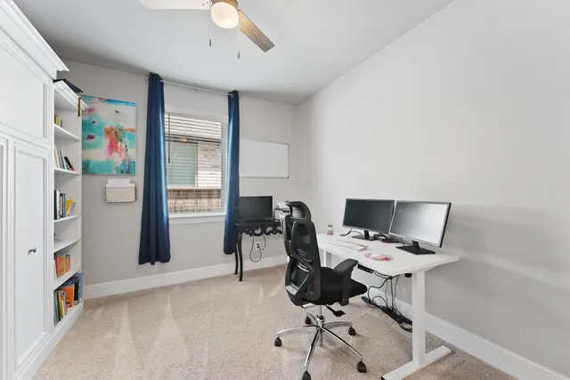 a view of a workspace with furniture and a window