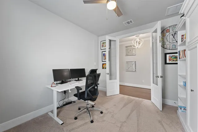 a view of a workspace with furniture and a window