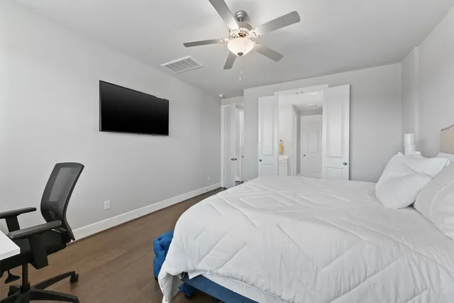 a spacious bedroom with a bed and a flat screen tv