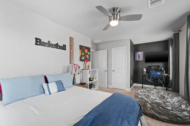 a bedroom with a bed and a flat tv screen on the dresser