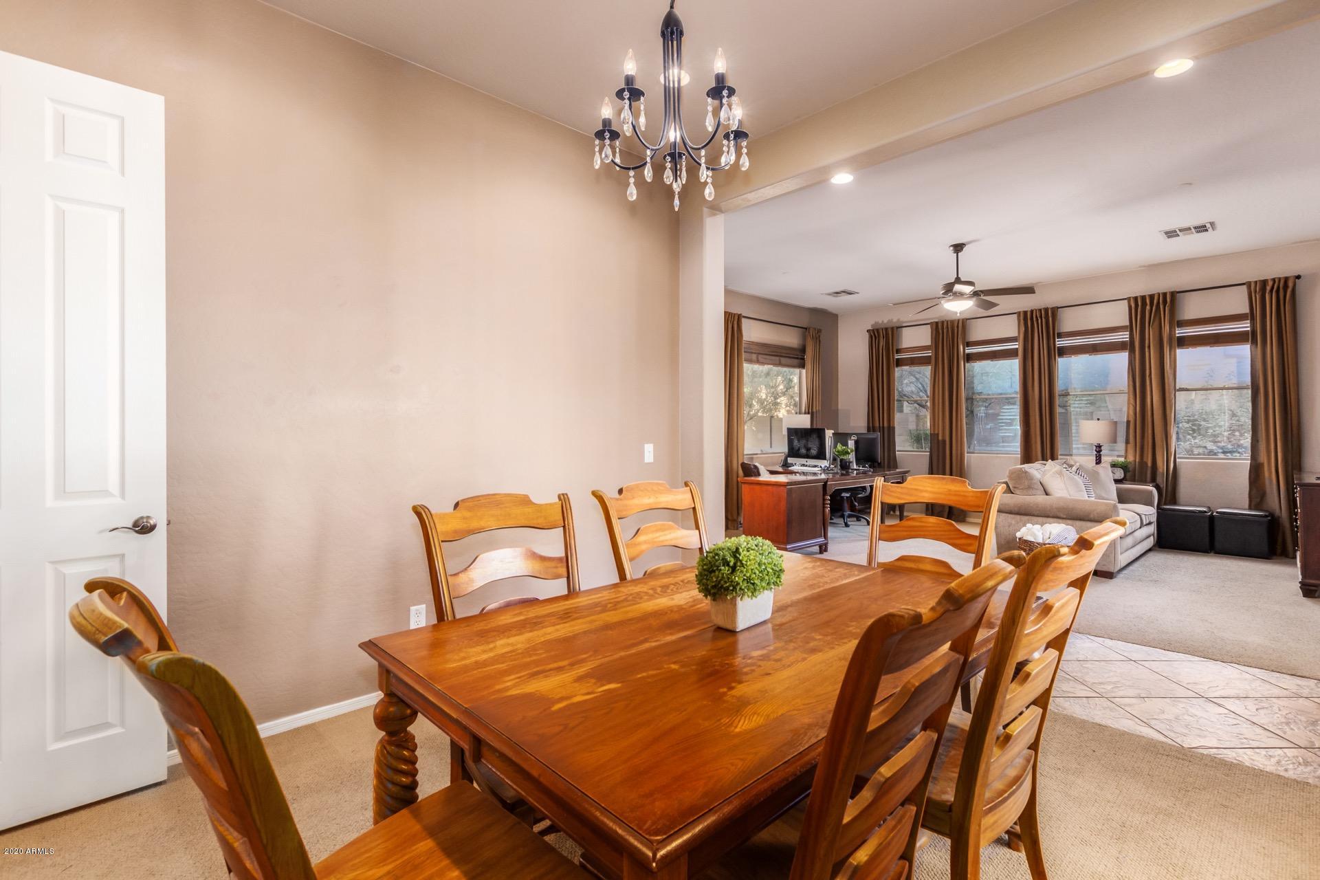 1043 Phelps Street Gilbert, AZ 85295 - Photo 15 of 18 a view of a dining room with furniture a chandelier and large windows