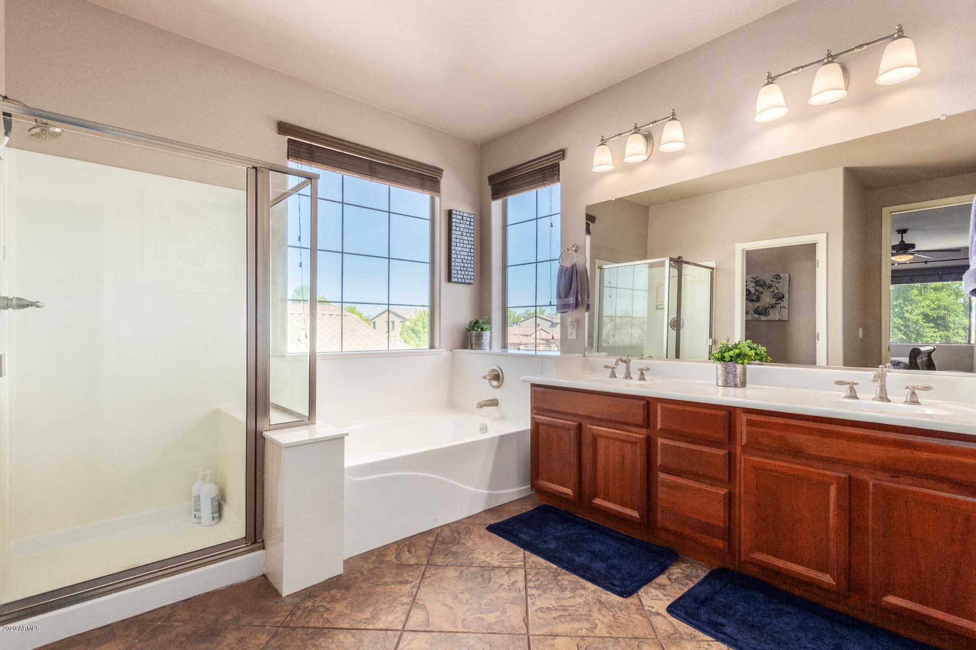1043 Phelps Street Gilbert, AZ 85295 - Photo 8 of 18 a spacious bathroom with a tub sink and mirror