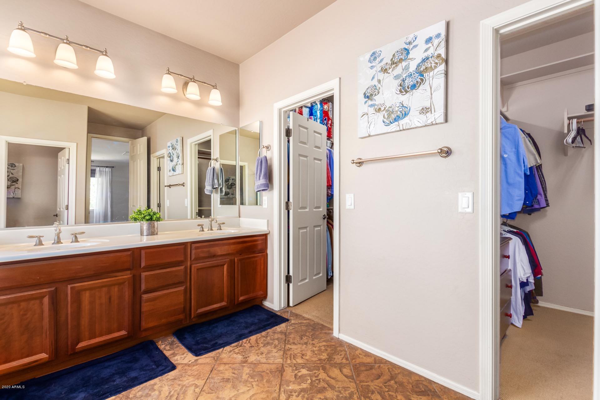 1043 Phelps Street Gilbert, AZ 85295 - Photo 9 of 18 a spacious bathroom with a double vanity sink and a mirror