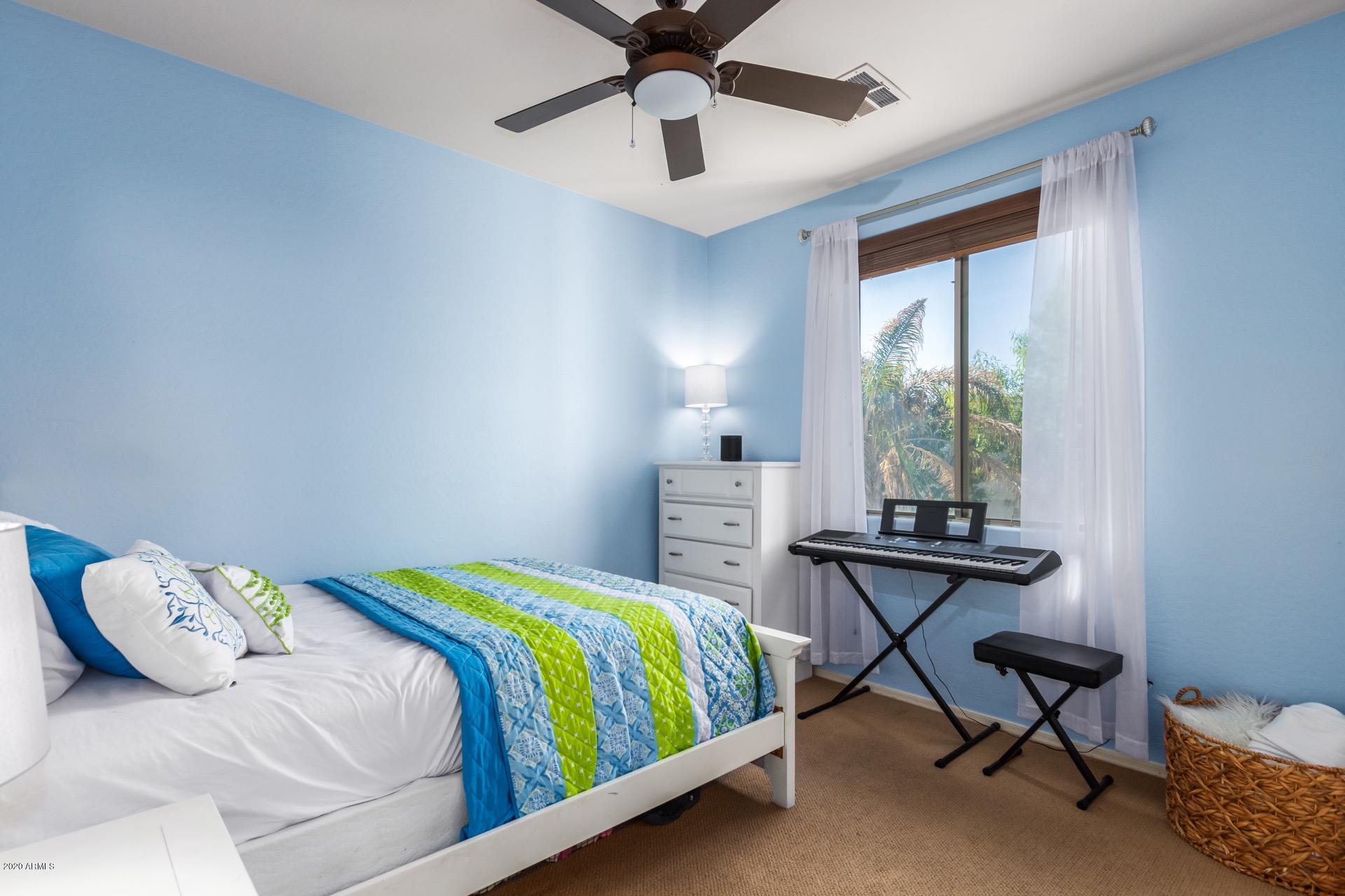 1043 Phelps Street Gilbert, AZ 85295 - Photo 10 of 18 a bedroom with a bed and a chandelier