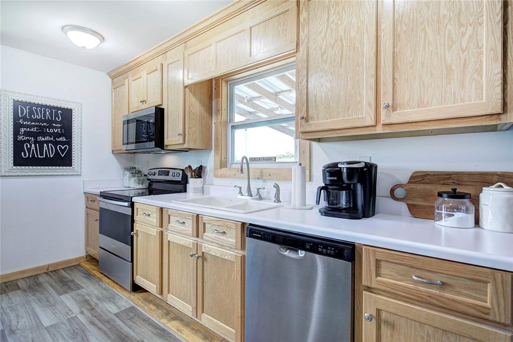 765 Addison Road Buchanan, GA 30113 - Photo 11 of 50 a kitchen with stainless steel appliances granite countertop a sink a stove and microwave with wooden floor