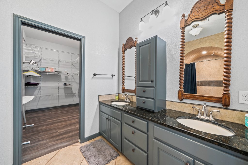 209 Lakeview Circle Spring Branch, TX 78070 - Photo 18 of 40 Full bath with double vanity, tile patterned flooring, a sink, and a walk in closet