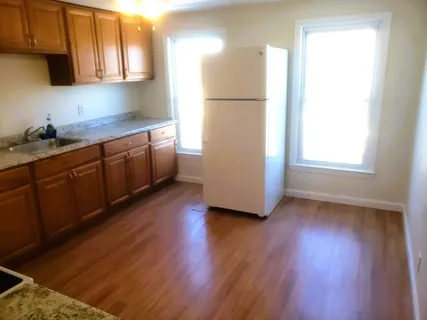 a kitchen with wooden floors and white cabinets