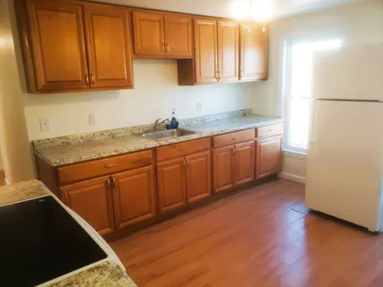 a kitchen with stainless steel appliances granite countertop a sink a stove and a refrigerator