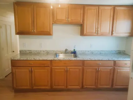 a kitchen with granite countertop white cabinets and sink
