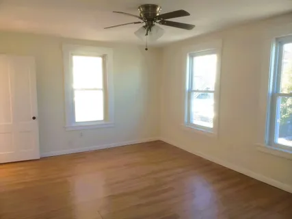 a view of a livingroom with a window and wooden floor
