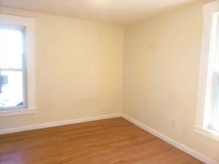 a view of a small space with wooden floor and a window
