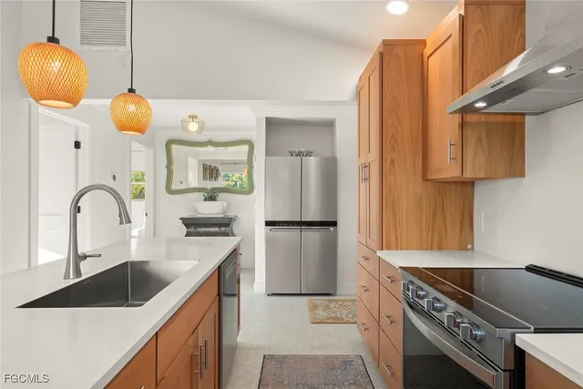a kitchen with stainless steel appliances granite countertop a sink a stove and a refrigerator