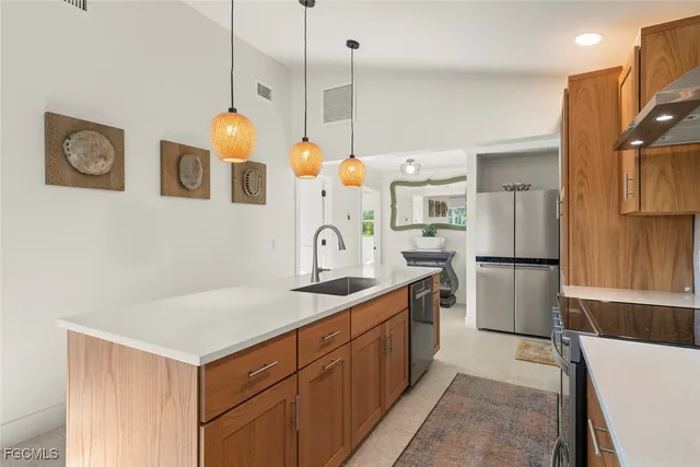 a kitchen with a sink a refrigerator and a stove