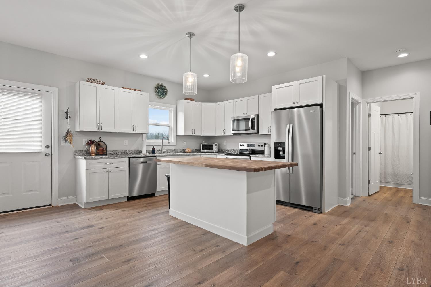 351 Down Creek Road Brookneal, VA 24528 - Photo 16 of 42 a kitchen with stainless steel appliances granite countertop a refrigerator a sink dishwasher a stove and white cabinets with wooden floor