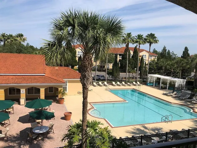 a view of a house with backyard patio and swimming pool