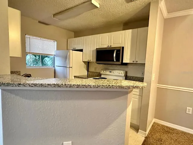 a kitchen with stainless steel appliances granite countertop a sink and a microwave