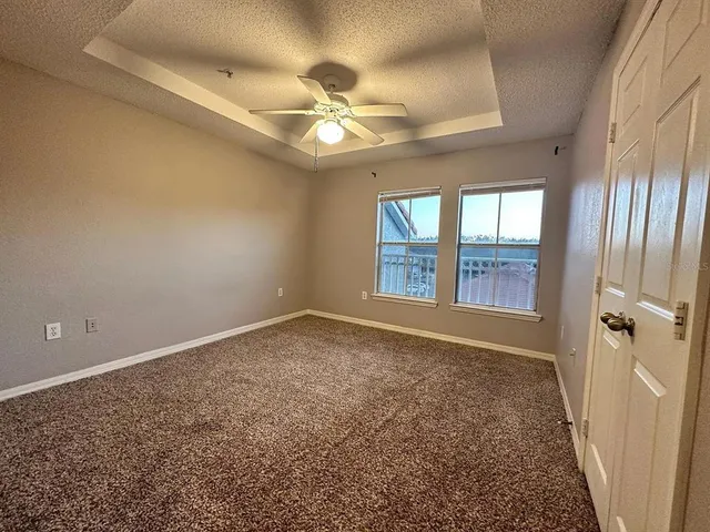 an empty room with windows and fan