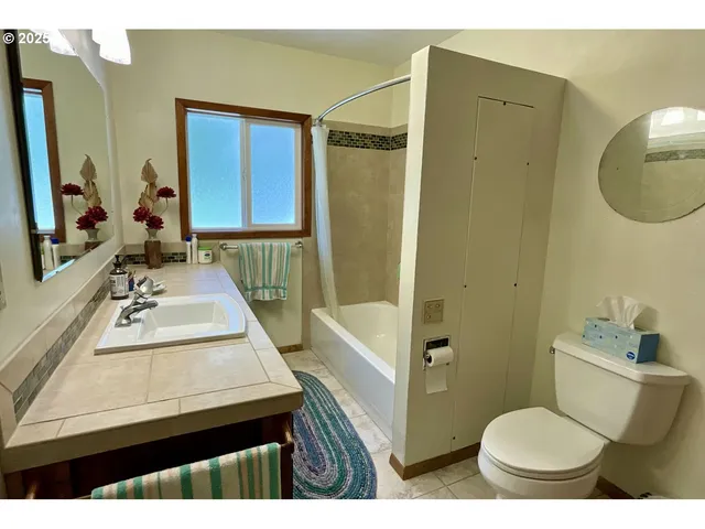 a bathroom with a sink a toilet a mirror and shower