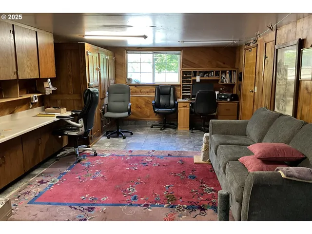 a living room with furniture a rug and kitchen view