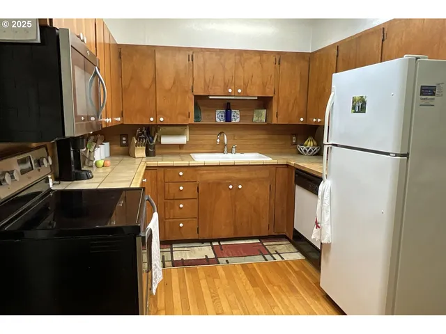 a kitchen with a appliances a sink a stove and cabinets