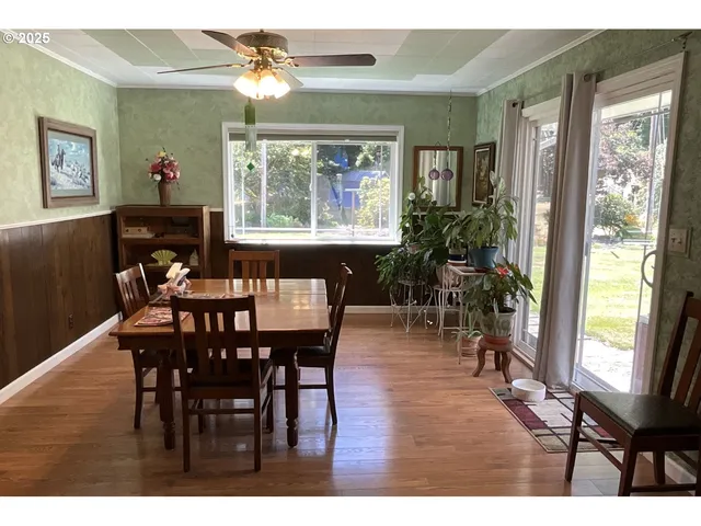 a dining room with wooden floor a chandelier a wooden table and chairs