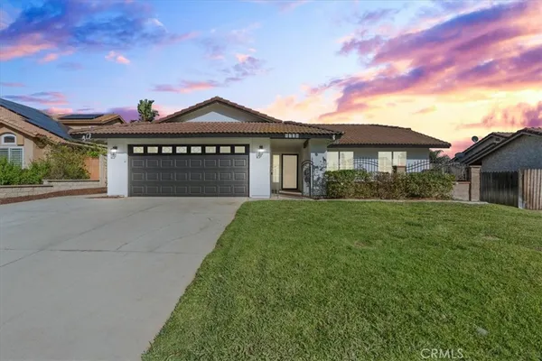 a front view of a house with a garden and yard