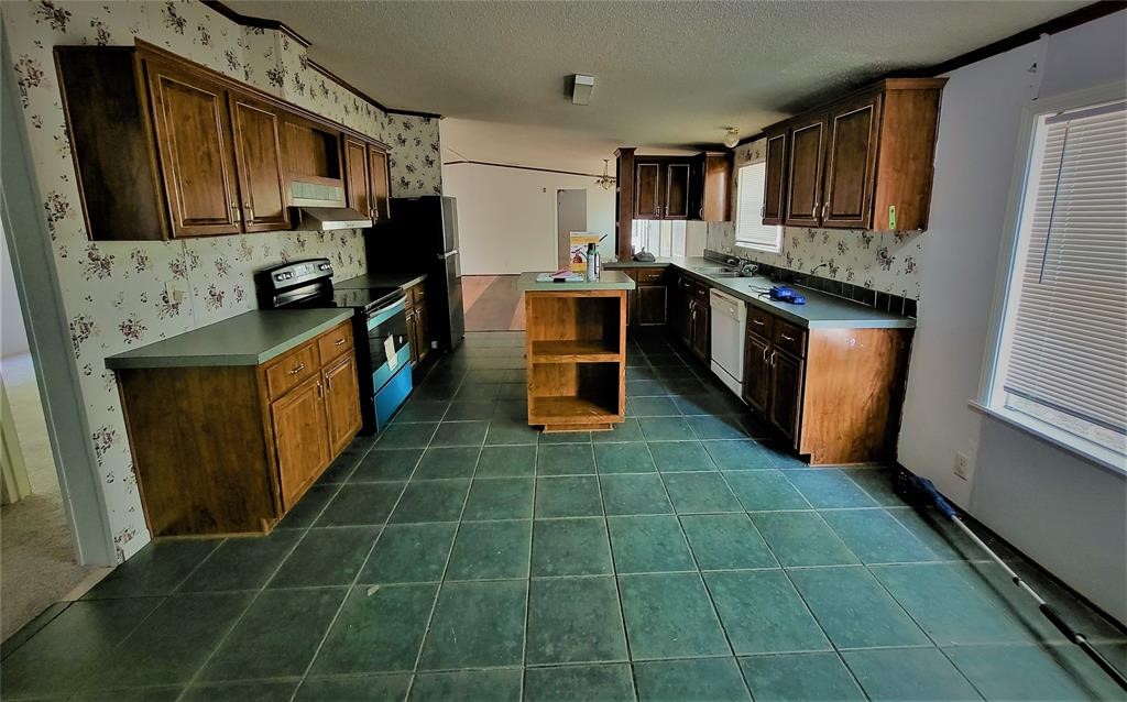 14536 Cochran Road Waller, TX 77484 - Photo 8 of 14 a kitchen with stainless steel appliances granite countertop a sink stove and refrigerator