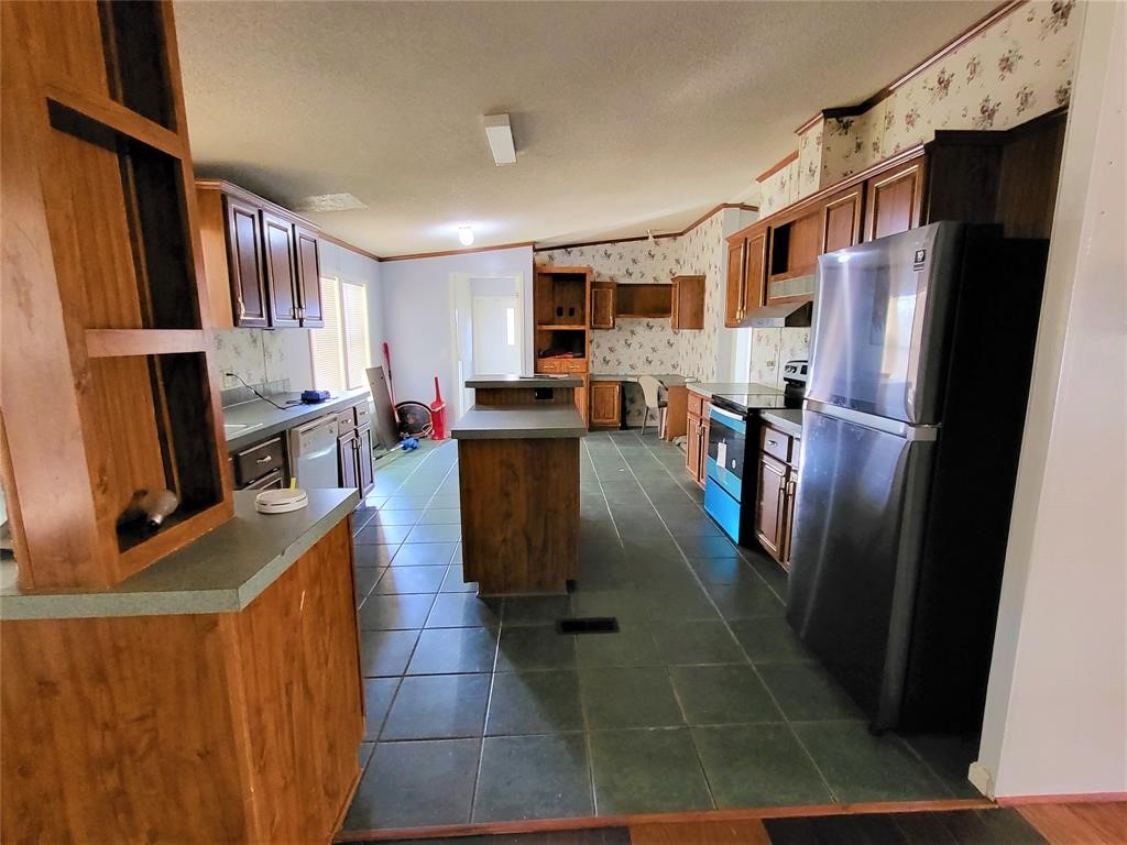 14536 Cochran Road Waller, TX 77484 - Photo 9 of 14 a kitchen with stainless steel appliances granite countertop a refrigerator stove microwave and sink
